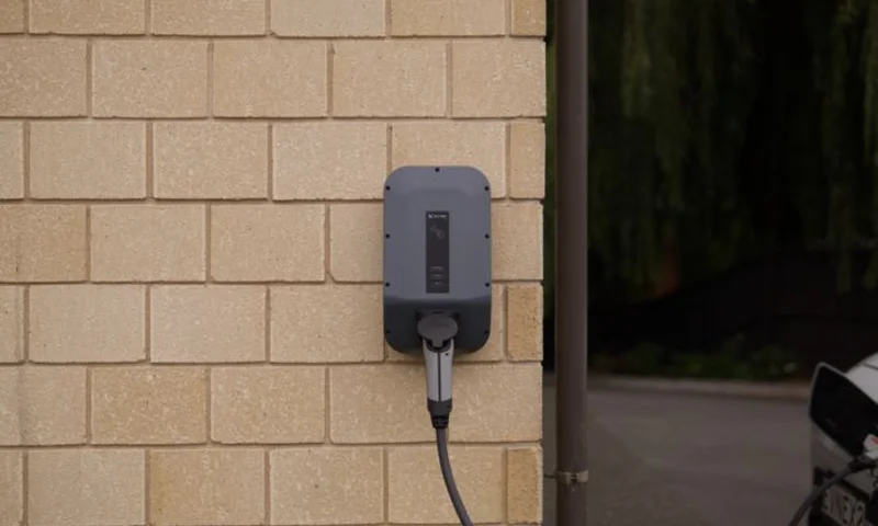 Wall-mounted home EV charger on a brick garage wall