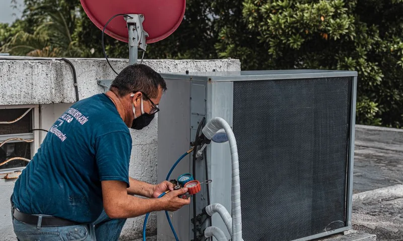 Technician repairing a central air conditioner outdoor unit