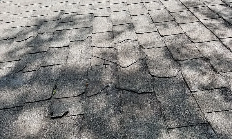 Roofer installing asphalt shingles